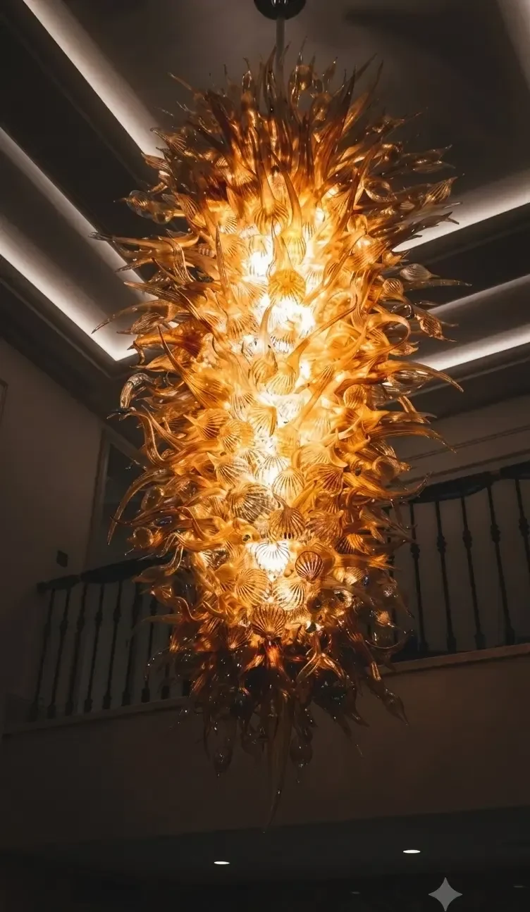 Illuminated amber-gold glass chandelier in a grand interior
