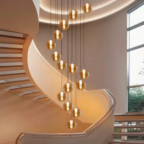 Custom multi-pendant glass sphere chandelier spiralling above a staircase