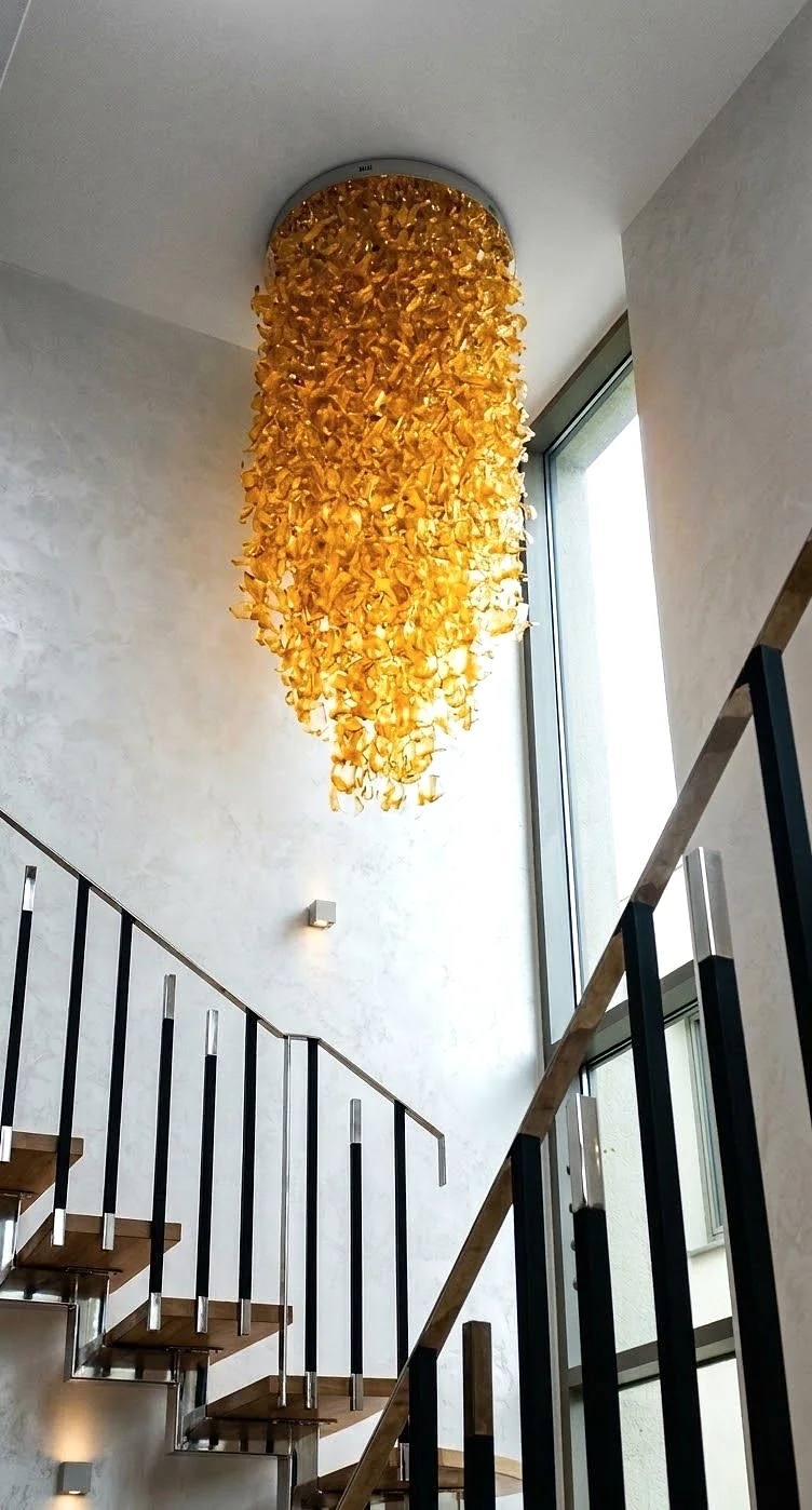 Tall amber glass cascade chandelier over a modern stairwell