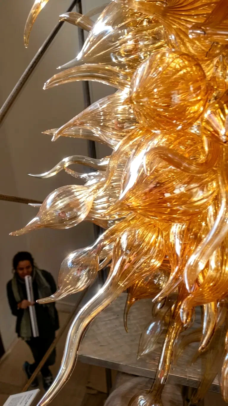 Close-up of a golden Murano glass petal chandelier, lit and glowing